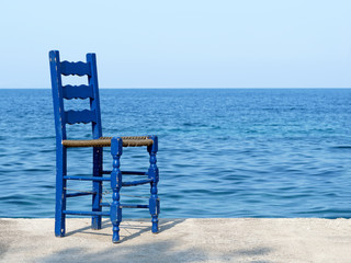 Blue chair by the sea in Greece