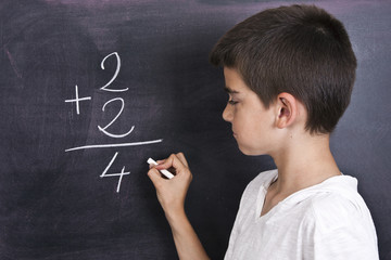 child in school blackboard with mathematical formula