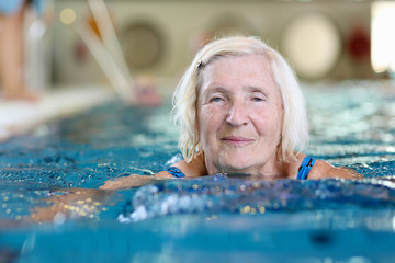 Healthy active senior woman swimming in the pool - obrazy, fototapety, plakaty