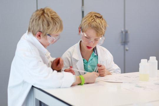 Two school boys having chemistry lesson in the lab