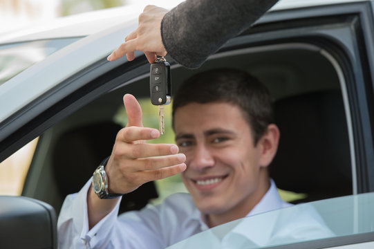 Salesman handing over keys car businessman