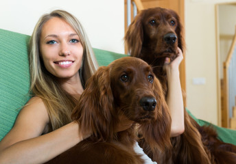 Girl with two Irish setters at home