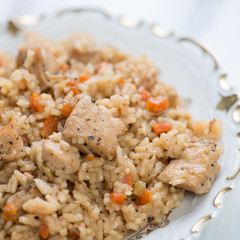 Close-up of pilaf with chicken in a glass plate, studio shot