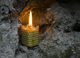 Burning beeswax candle in the cave