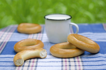 Bagels and mug with milk on tartan tablecloth