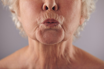 Mature woman puckering lips - obrazy, fototapety, plakaty