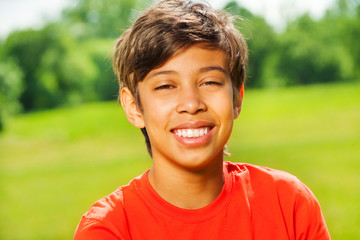 Brunet smiling boy in red T-shirt portrait