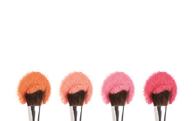 Cosmetics Makeup brushes with orange,pink and red powder.