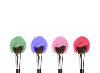 Cosmetics Makeup brushes with colorful powders.