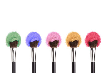 Cosmetics Makeup brushes with colorful powders.