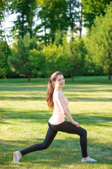Sporty girl doing stretching exercise outdoors