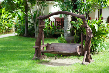 Old wood swing in the green garden