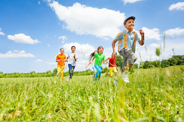 Happy kids playing and running in the field