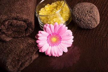 Obraz na płótnie Canvas SPA still life with towels and gerberas on the brown surface