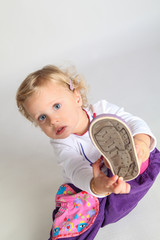 kleines Mädchen zieht sich einen Schuh an