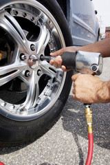 Auto mechanic changing car wheel