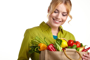 Portrait of happy young woman holding a shopping bag full of gro