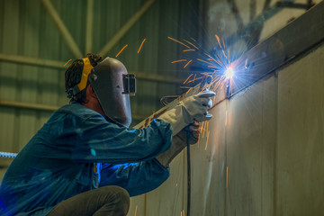 Worker welding the steel part by manual