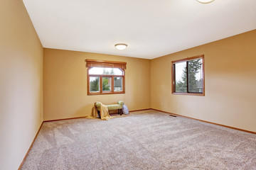 Fototapeta premium Empty bedroom interior in soft peach color with ottoman