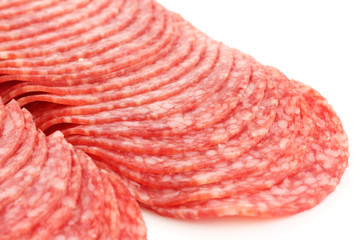 Freshly sliced salami rounds on white.