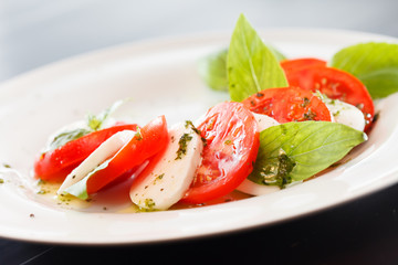 Tomato and mozzarella with basil leaves