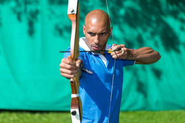 Archer aiming at target with bow and arrow