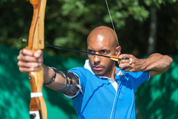 Archer aiming at target with bow and arrow
