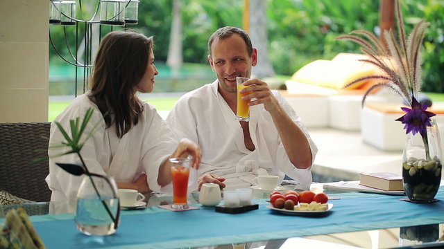Couple talking during relax by table in luxury villa