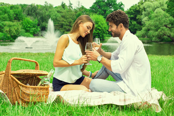 Couple at park having a picnic and drinking white wine