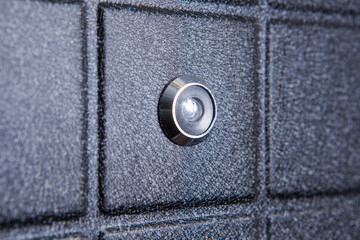 Black iron door of squares with silver peephole
