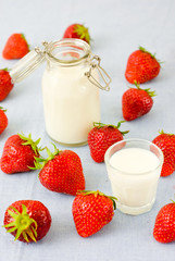 Fresh strawberries and milk on light blue background