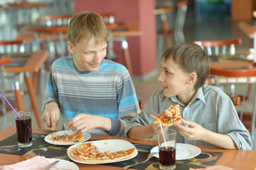 Boys eating pizza