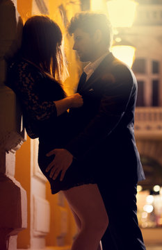Man and woman kissing at night