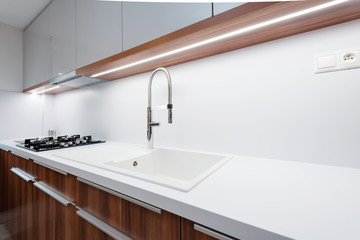 Sink with tap on white worktop in contemporary kitchen