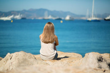 Young girl sitting on the sea shore