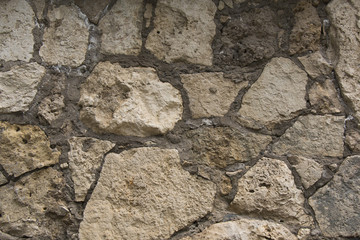 Fragment of an old wall made of natural stone