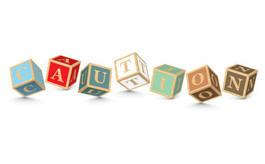 Word CAUTION written with alphabet blocks