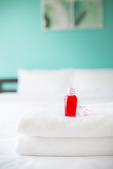 Fototapeta na wymiar Freshly laundered white fluffy towels with shower gel in bedroom