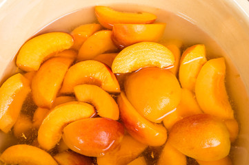 Bowl of fresh sliced peaches in syrup