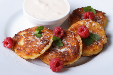 Cheese pancakes with raspberries and sour cream top view
