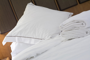 Fototapeta na wymiar Hotel bed pillow and white sheets
