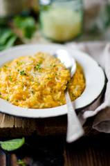 Carrot risotto in the plate on wooden table