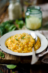 Carrot risotto in the plate on wooden table