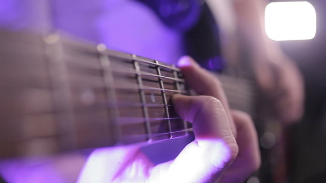 man plays guitar left-handed