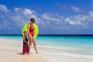 Fototapeta na wymiar mother and son go swimming at tropical beach