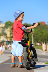 little boy riding bike in the city