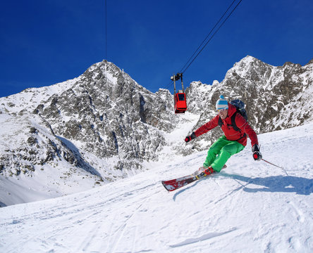 Skier against cable-lift in high mountains