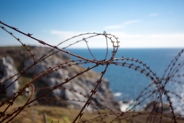 Barbed wire on fence with Atlantic ocean