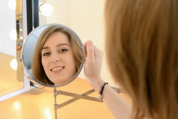 Teenager schaut in Schminkspiegel
