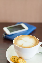 Cup of coffee and biscuits on wooden board